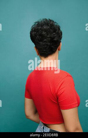 Giovane Latina Donna sulla schiena con una t-shirt rossa , foto verticale isolata, sfondo verde acqua corrente Foto Stock