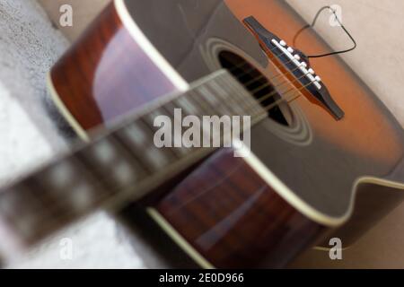 Vista dalla parte superiore della chitarra acustica. Mettere a fuoco sulla sella. Concetto di strumento a stringa musicale Foto Stock