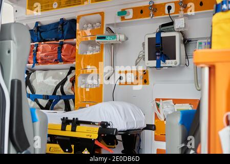 Interno di un'auto ambulanza contemporanea dotata di vari strumenti professionali e barella medica Foto Stock