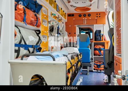 Interno di un'auto ambulanza contemporanea dotata di vari strumenti professionali e barella medica Foto Stock