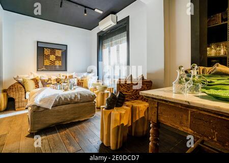 Design interno di spaziosa camera da letto luminosa con letto confortevole e. tavolo d'epoca e pavimento in legno in una casa moderna Foto Stock