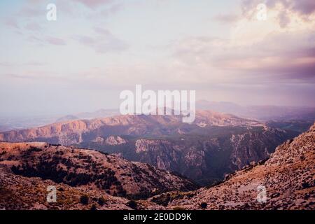 Paesaggio mozzafiato della montagna la Pandera con le cime rocciose e. Alberi verdi situati contro il cielo nuvoloso tramonto nella provincia di Jaen Foto Stock