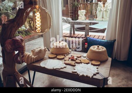 Tavolo con varie montagne russe di legno e coperte di cibo di bambù disposti In camera con decorazioni tradizionali nell'hotel di Taiwan Foto Stock