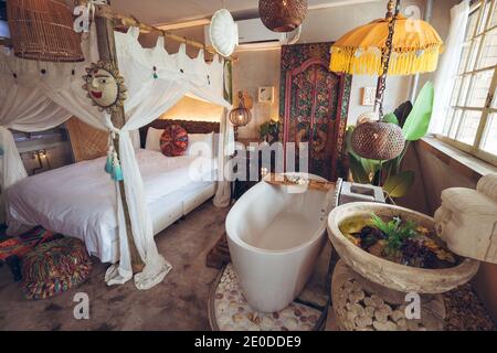 Letto confortevole con baldacchino e vasca bianca nell'hotel camera con arredi e decorazioni orientali tradizionali a Taiwan Foto Stock