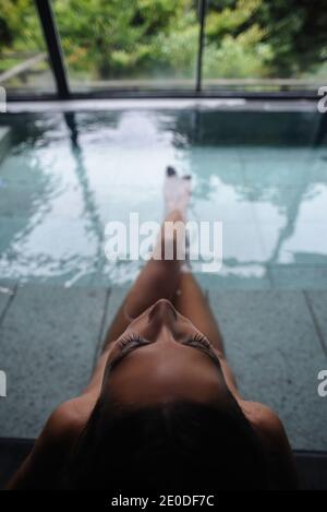 Giovane donna caucasica godendo.un bagno rilassante in un onsen giapponese, vista dall'alto Foto Stock