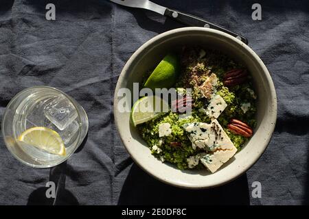 Da sopra ciotola con insalata di broccoli con couscous messo sopra tovagliolo in tessuto scuro Foto Stock