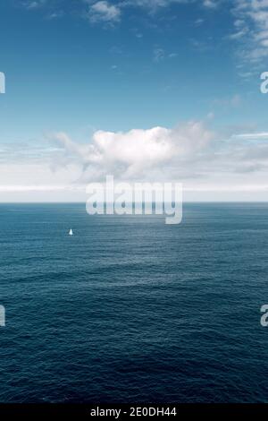 Vista tranquilla del mare blu ondulazione sotto il cielo con le nuvole Il giorno di sole su Gaztelugatxe Foto Stock