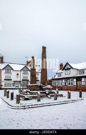 L'antica pietra sassone attraversa la piazza del mercato ricoperta di neve in inverno al Sandbach Cheshire di fronte al Market Tavern inn Foto Stock