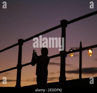 Sidmouth, Devon, 31 dicembre 2020 sul lungomare di Sidmouth, il sole tramonta per l'ultima volta il 2020, un anno molti saranno lieti di dire Arrivederci a. Il sole sta anche tramontando i legami della Gran Bretagna con le normative europee, che terminano alle 11.00 di questa sera. Credit: Photo Central/Alamy Live News Foto Stock