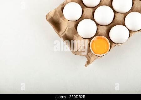Uova di pollo crude in scatola di uova su sfondo bianco Foto Stock