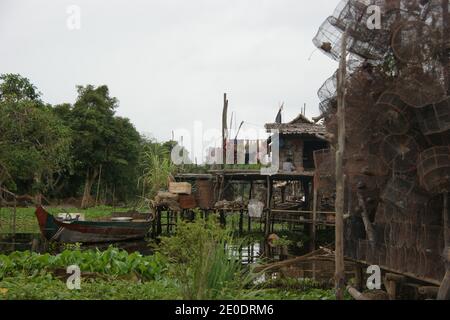 Attrezzatura da pesca e barca ormeggiata accanto a una casa nel villaggio galleggiante di Kampong Phluk su Tonle SAP. Foto Stock