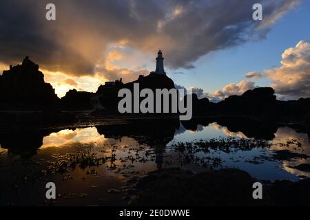 Faro la Corbiere, Jersey, Regno Unito Coastal paesaggio invernale e struttura riflessa in una piscina marea. Foto Stock