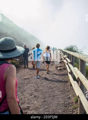 Gruppo di persone escursioni Mt. Vesuvio in Italia. Giornata di sole con nebbia. Foto Stock