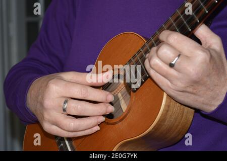 Donna che gioca 5 corde tenore ukulele, sezione centrale, fuoco selettivo Foto Stock