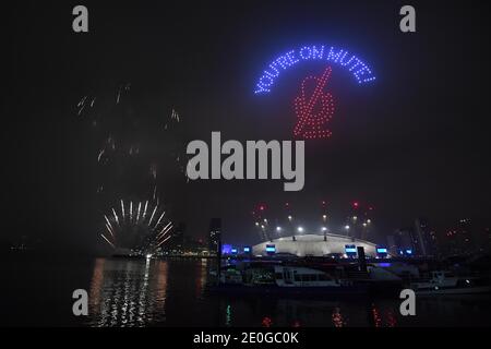 Fuochi d'artificio e droni illuminano il cielo notturno su Londra formando un'esposizione luminosa, in quanto la normale esposizione dei fuochi d'artificio di Capodanno di Londra è stata annullata a causa della pandemia del coronavirus. Foto Stock