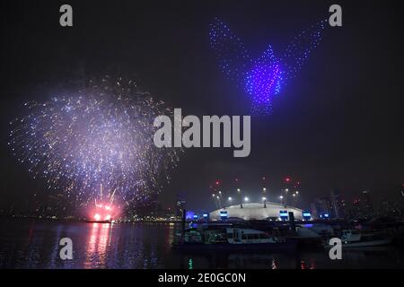 Fuochi d'artificio e droni illuminano il cielo notturno su Londra formando un'esposizione luminosa, in quanto la normale esposizione dei fuochi d'artificio di Capodanno di Londra è stata annullata a causa della pandemia del coronavirus. Foto Stock