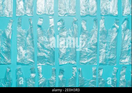 Disposizione piatta con una moltitudine di sacchetti di plastica allineati su uno sfondo blu. Svuotare i sacchetti monouso sopra la vista. Vista dall'alto dei sacchetti in foglio di alluminio con sbriciolati. Foto Stock