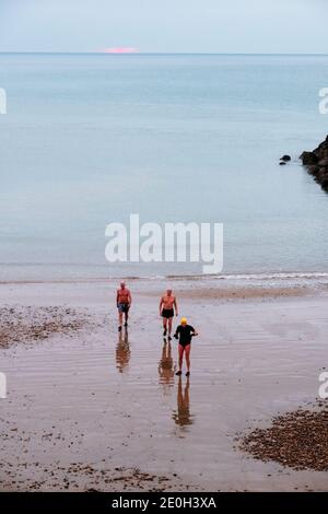 Hastings; Sussex orientale; Regno Unito. 1st gennaio 2021. I nuotatori di Capodanno fanno un tuffo in mare all'alba in una mattinata fredda con la temperatura appena sopra il gelo e con solo un breve sguardo del sole in una giornata nuvolosa. C.Clarke/Alamy Live News Foto Stock