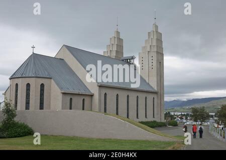 Akureyri, Islanda - 27 luglio 2017: Il lato posteriore della chiesa di Akureyrarkirkja ad Akureyri in Islanda e la gente che va per il servizio. Foto Stock