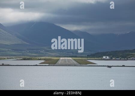 Vista dalla fine della pista ad Akureyri aeroporto in Islanda. Un piccolo aereo è tenuto spento. Foto Stock
