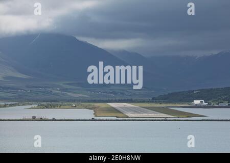 Vista dalla fine della pista ad Akureyri aeroporto in Islanda. Un piccolo aereo è tenuto spento. Foto Stock