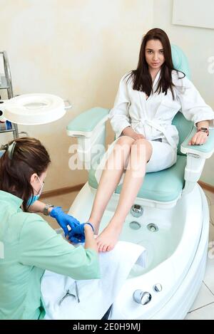 Donna piedi pedicure di ricezione. Estetista facendo pedicure. Close up concetto. Foto Stock