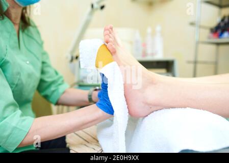 Donna ottenendo un pedicure e relax presso il salone di bellezza. Trattamento piedi in SPA salone. Clinica podologia. Foto Stock