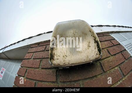 Cambridge , UK , Inghilterra, 31-12-2020, Fisheye vista della vecchia luce di sicurezza elettrica intemperie sul lato dell'edificio abbandonato Foto Stock