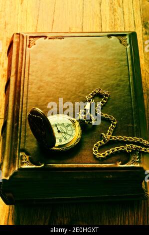 vecchio libro in pelle e orologio da tasca Foto Stock