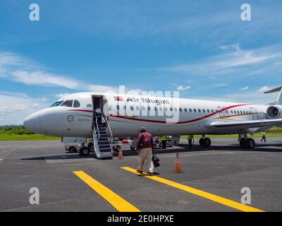 I passeggeri che salpano a bordo di un Fokker 100 chiamato Città del Laé da Air Niugini all'aeroporto di Wewak, chiamato anche Aeroporto di Boram, a Wewak, la capitale dell'East Sep Foto Stock