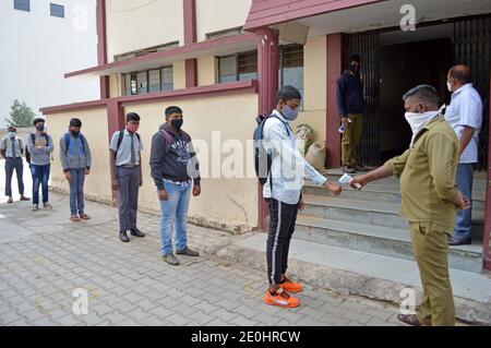 Bangalore, India. 1 gennaio 2021. Un insegnante controlla la temperatura corporea di uno studente in una scuola a Bangalore, India, 1 gennaio 2021. Lo stato meridionale del Karnataka il venerdì ha aperto le scuole per gli studenti dei gradi 10 e 12 dopo un intervallo di più di nove mesi. Credit: Sr/Xinhua/Alamy Live News Foto Stock