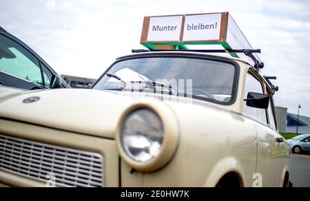 Dangast, Germania. 01 gennaio 2021. Un segno che dice "Munter bleiben!" È montato su un vecchio Trabant parcheggiato in un parcheggio sulla spiaggia. Credit: Hauke-Christian Dittrich/dpa/Alamy Live News Foto Stock