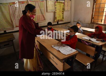 31 dicembre 2020, Guwahati, Assam, India: Un insegnante mostra agli studenti come lavare i papà dopo la riapertura della scuola primaria nello stato da oggi dopo nove mesi a causa di pamdemics coranavirus alla scuola primaria Uzanbazar Jahaj Ghat a Guwahati Assam India venerdì 1 gennaio 2021. (Immagine di credito: © Dasarath Deka/ZUMA Wire) Foto Stock