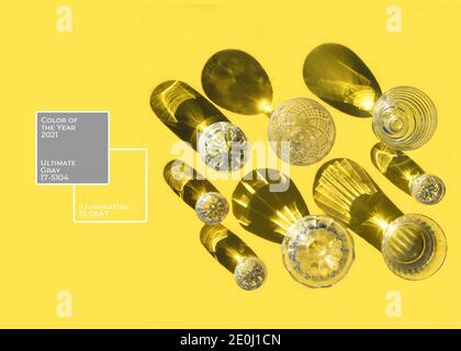 Occhiali con ombra. Vista dall'alto. Colore dell'anno 2021. Illuminazione e Ultimate Grey. Sfondo giallo e grigio Foto Stock