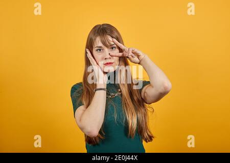 Alzando due dita sulla mano è mostra la lotta di forza di pace o simbolo di vittoria e lettera v in lingua dei segni. Il gesto numero 2, sorride splendidamente, mostrando Foto Stock