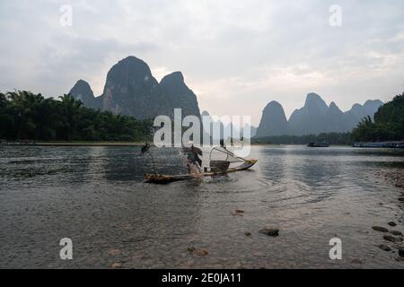 La Cina cormorana pesca il fiume li al tramonto Foto Stock