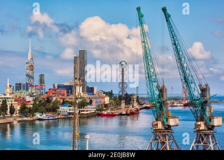 Paesaggio urbano lungo la costa del Mar Caspio, Torre dell'Università tecnologica di Batumi con ruota panoramica costruita nella facciata, Torre di porta Batumi e. Foto Stock