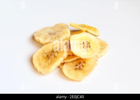 Mucchio di fette di banana asciutte isolate su sfondo bianco. Fiches di frutta secca Foto Stock