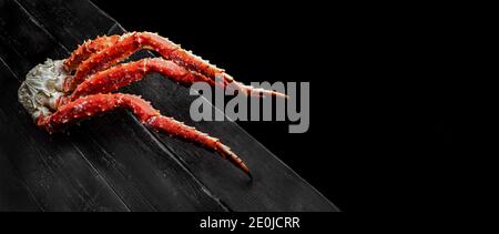 Fresco rosso granchio granchio artigli su sfondo di legno vintage. Gustosa artiglietta di granchio kamchatka. Vista superiore con spazio di copia. Foto Stock