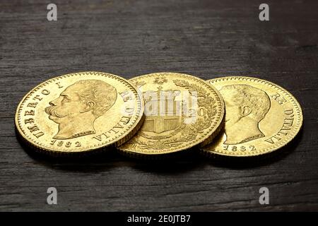 Monete d'oro italiane da 20 Lira su sfondo rustico in legno Foto Stock