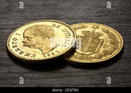 Monete d'oro italiane da 20 Lira su sfondo rustico in legno Foto Stock