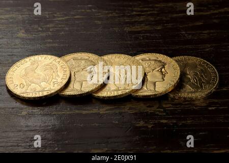 Monete d'oro francesi da 20 franchi su fondo rustico in legno Foto Stock