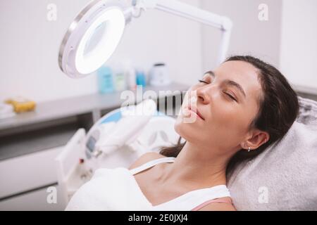 Primo piano di una giovane bella donna che visita la clinica di bellezza per la cura della pelle. Donna attraente su appuntamento dermatologo o cosmetologo Foto Stock
