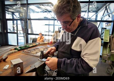 I lavoratori sono visti presso la fabbrica di coltelli 'la Forge de Laguiole' il 19 settembre 2012 a Laguiole, Francia centrale. I residenti di Laguiole, un villaggio sinonimo dei coltelli più famosi della Francia, hanno simbolicamente 'senza nome' la loro casa in una protesta per aver perso il controllo sul nome. Gli abitanti del villaggio sono furiosi che il nome Laguiole è passato nelle mani di un imprenditore che gli permette di essere utilizzato per vendere coltelli made-in-China e barbecue. Foto di Pascal Parrot/ABACAPRESS.COM Foto Stock