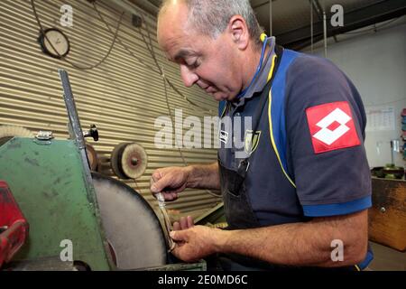 I lavoratori sono visti presso la fabbrica di coltelli 'la Forge de Laguiole' il 19 settembre 2012 a Laguiole, Francia centrale. I residenti di Laguiole, un villaggio sinonimo dei coltelli più famosi della Francia, hanno simbolicamente 'senza nome' la loro casa in una protesta per aver perso il controllo sul nome. Gli abitanti del villaggio sono furiosi che il nome Laguiole è passato nelle mani di un imprenditore che gli permette di essere utilizzato per vendere coltelli made-in-China e barbecue. Foto di Pascal Parrot/ABACAPRESS.COM Foto Stock