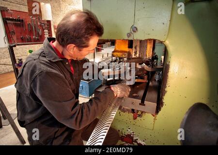 I lavoratori sono visti presso la fabbrica di coltelli 'la Forge de Laguiole' il 19 settembre 2012 a Laguiole, Francia centrale. I residenti di Laguiole, un villaggio sinonimo dei coltelli più famosi della Francia, hanno simbolicamente 'senza nome' la loro casa in una protesta per aver perso il controllo sul nome. Gli abitanti del villaggio sono furiosi che il nome Laguiole è passato nelle mani di un imprenditore che gli permette di essere utilizzato per vendere coltelli made-in-China e barbecue. Foto di Pascal Parrot/ABACAPRESS.COM Foto Stock