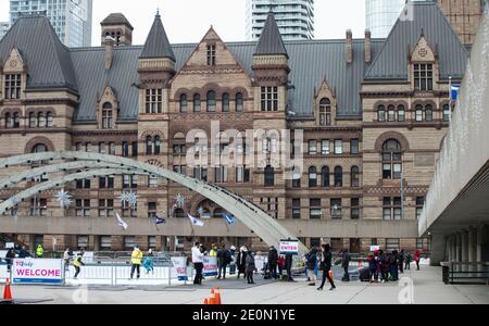 Toronto, Canada. 1 gennaio 2021. Le persone si allineano per pattinare fuori da una pista di pattinaggio all'aperto a Nathan Phillips Square a Toronto, Canada, il 1° gennaio 2021. Molti residenti a Toronto sono andati all'aperto a pattinare sul ghiaccio per festeggiare il primo giorno del 2021 venerdì. Credit: Zou Zheng/Xinhua/Alamy Live News Foto Stock