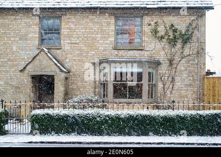 Cotswold casale in pietra sulla strada alta nella neve a natale. Shipton sotto Wychwood, Cotswolds, Oxfordshire, Inghilterra Foto Stock