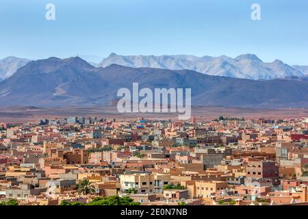 Una sezione della città di Tinerhir in Marocco con le magnifiche montagne dell'Alto Atlante sullo sfondo. Tinerhir è una città della regione di Draa-Tafilalet. Foto Stock