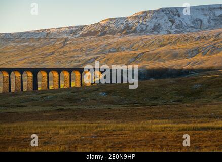 Luce d'oro che colpisce il magnifico Viadotto Ribblehead nello Yorkshire Dales Foto Stock